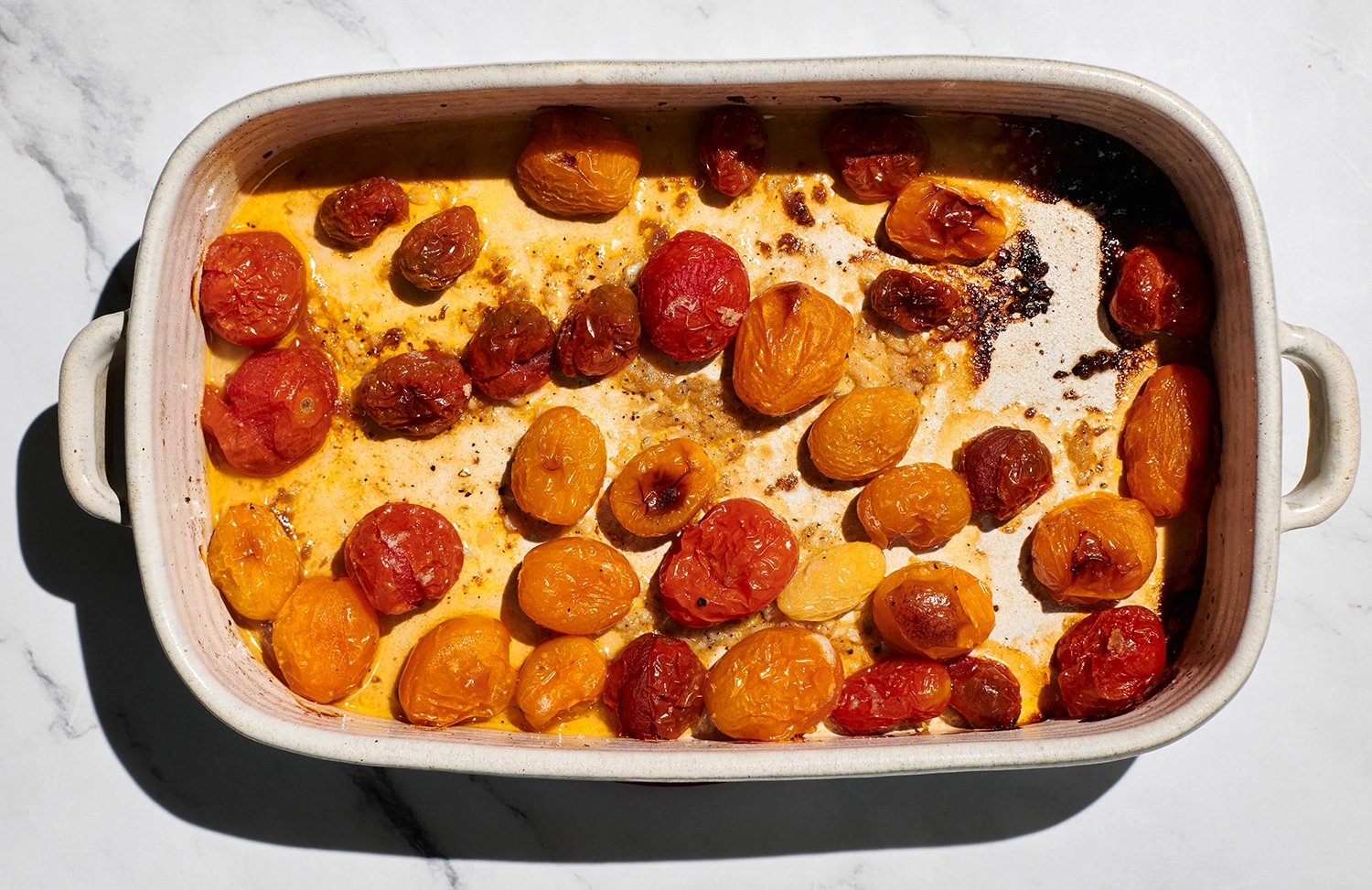 Cherry tomatoes tossed with sea salt, pepper, garlic, and a generous amount of olive oil roasted in a baking dish.