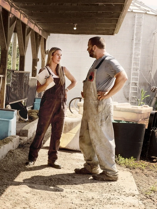 Dairy farmer and veterinarian talking beside cows in the barn