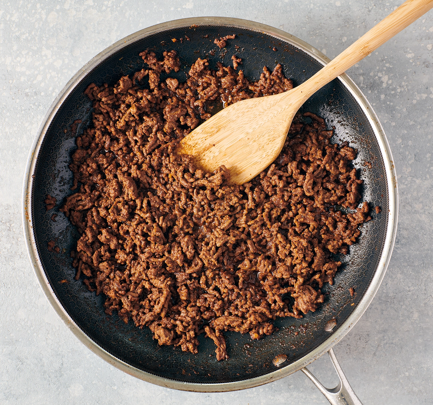 Ground beef cooked in a skillet over medium heat.