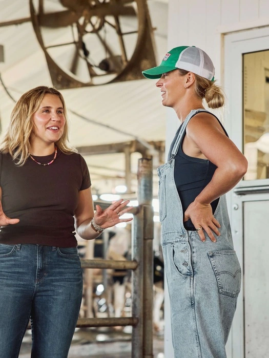 Two dairy farmers talking inside the barn